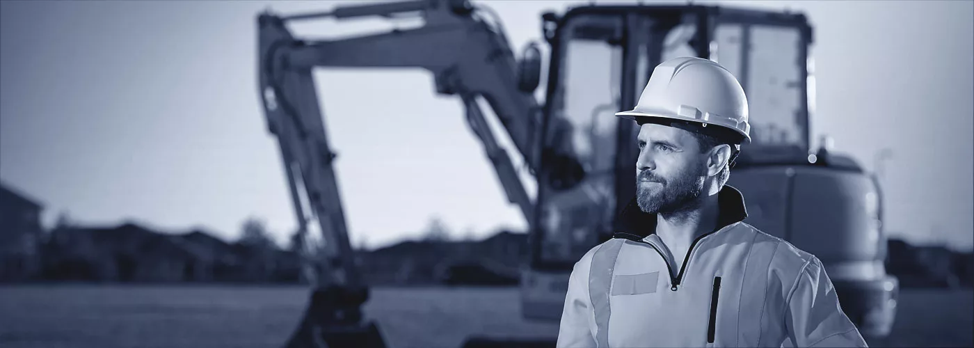 Ein Baggerfahrer steht neben seinem Fahrzeug.