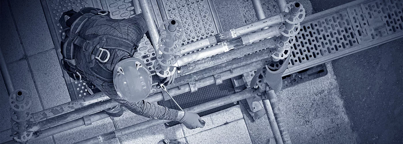 Ein Gerüstbauer beim Aufbauen eines Gerüsts.