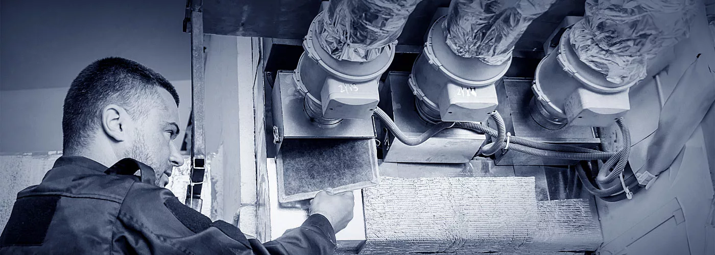 Ein Lüftungsmonteur beim überprüfen des Lüftungsfilters.