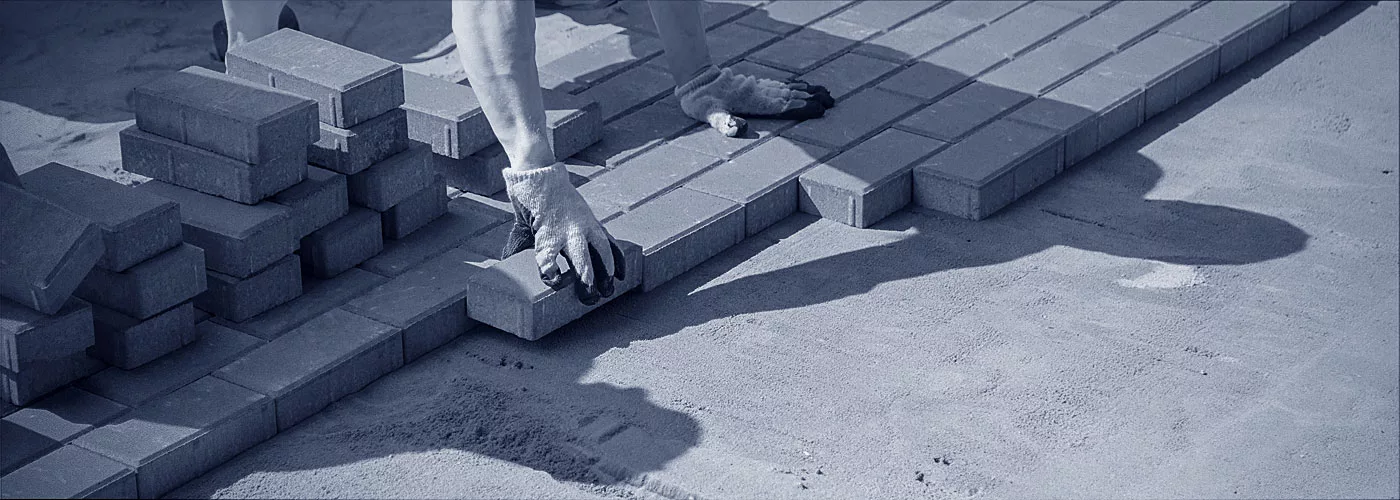Ein Pflasterer beim Verlegen von Steinen.