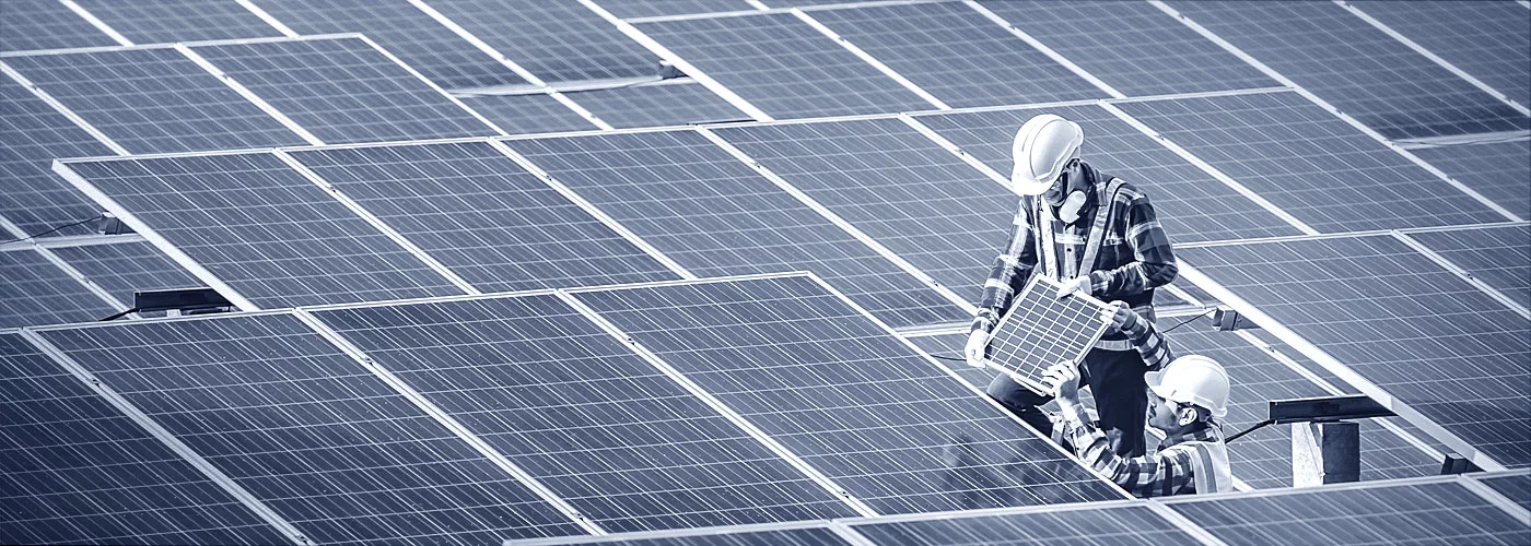 Zwei Monteure verlegen Photovoltaikplatten.