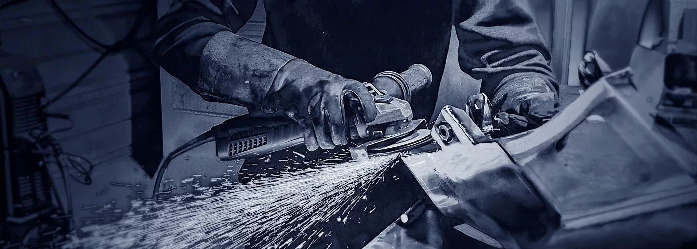 Ein Schlosser am Arbeiten mit einer Schleifmaschine.